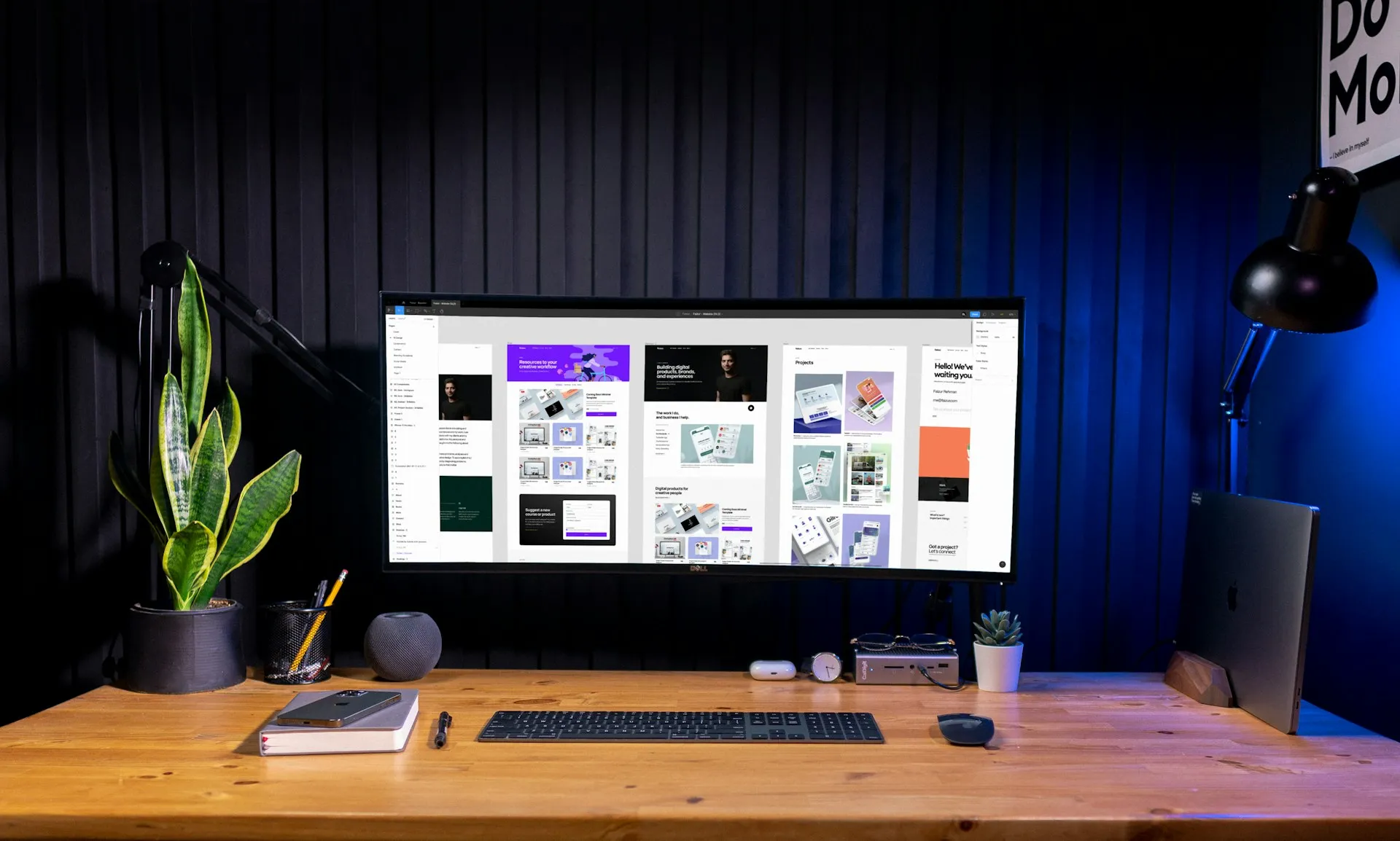 Een werkplek met een groot scherm vol websiteontwerpen
