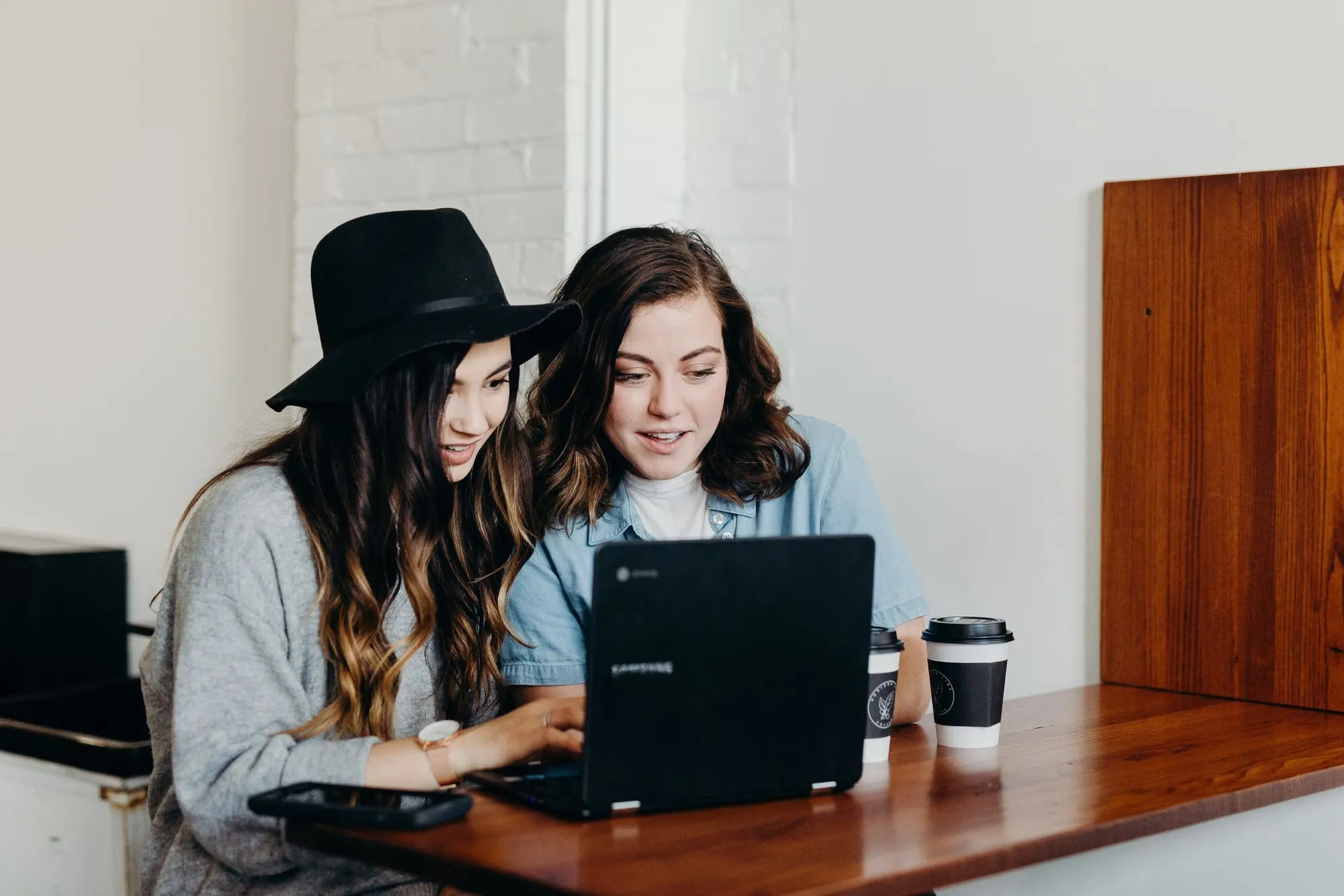 Twee makers kijken samen naar een project op een laptop